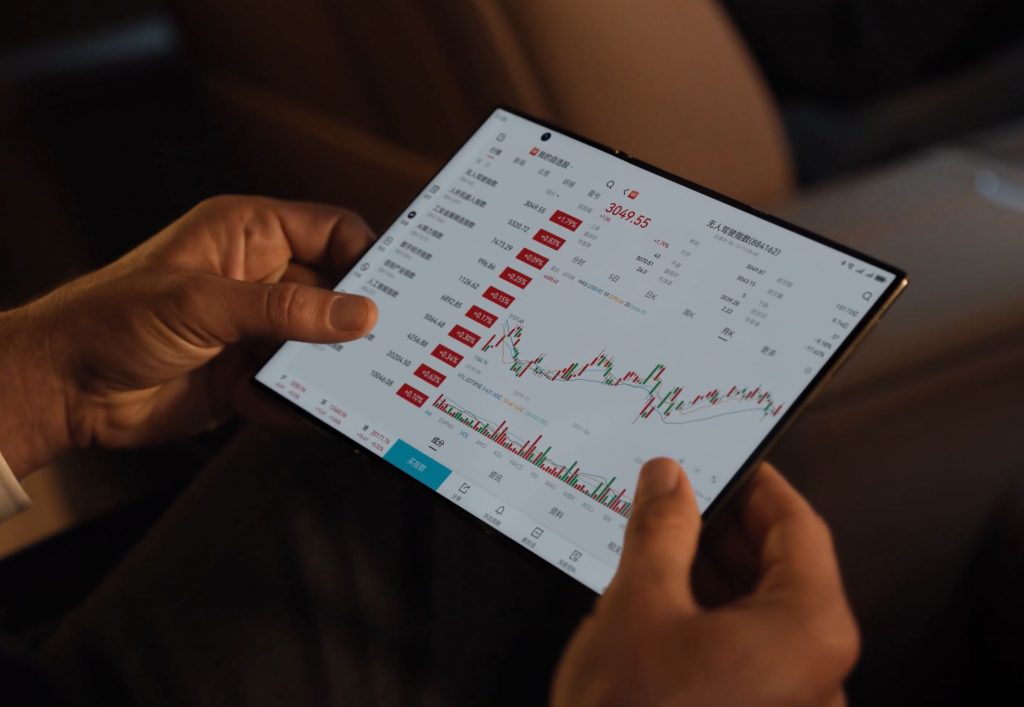 Smartphone pliable utilisé pour l'analyse de données financières, affichant un graphique boursier.