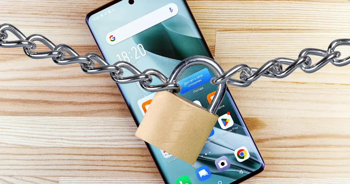 Smartphone verrouillé avec une chaîne et un cadenas sur une table en bois, symbolisant la sécurité des données mobiles.