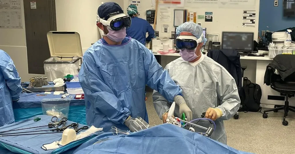 Deux chirurgiens en train d'utiliser des casques de réalité augmentée lors d'une opération dans une salle d'opération moderne.